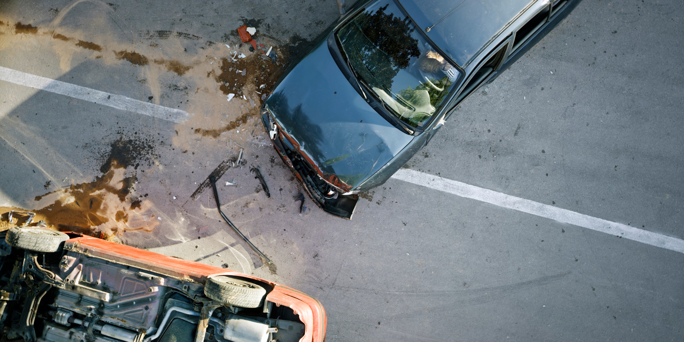 Overhead view of a severe auto wreck with two damaged cars on the road, illustrating the importance of legal assistance from Maher & Maher Law in accident cases