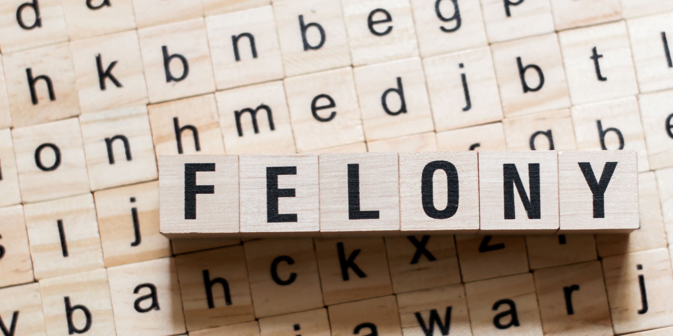 Colorado-Felony-Classifications-Explained Scrabble letters spelling the word FELONY on a wooden background, illustrating the concept of criminal charges for a blog post on Colorado felony classifications.